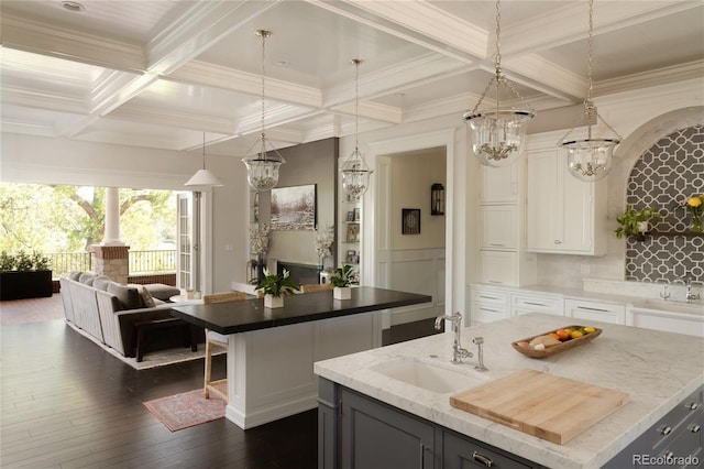 5470 S Highline Cir, Greenwood Village, CO 80121 - kitchen featuring a center island with sink, a sink, beamed ceiling, coffered ceiling, and white cabinetry