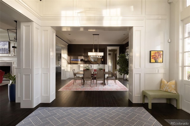 5470 S Highline Cir, Greenwood Village, CO 80121 - dining space with a decorative wall, dark wood-type flooring, ornamental molding, a chandelier, and a fireplace