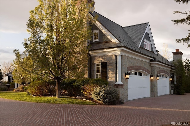 5470 S Highline Cir, Greenwood Village, CO 80121 - view of side of home with decorative driveway, stone siding, and a chimney
