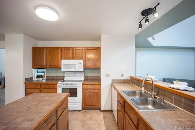 2035 Springcrest Rd, Colorado Springs, CO 80920 - kitchen with white appliances, tile counters, brown cabinets, light tile patterned floors, and a peninsula