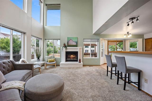 2035 Springcrest Rd, Colorado Springs, CO 80920 - living area with a towering ceiling, light colored carpet, plenty of natural light, and a brick fireplace