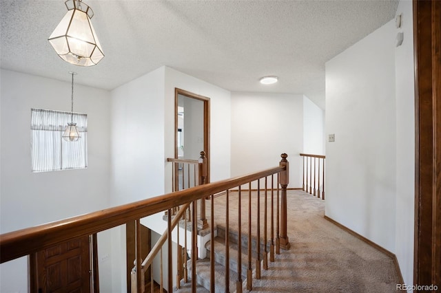 2035 Springcrest Rd, Colorado Springs, CO 80920 - hallway with an upstairs landing, light colored carpet, a textured ceiling, and a chandelier