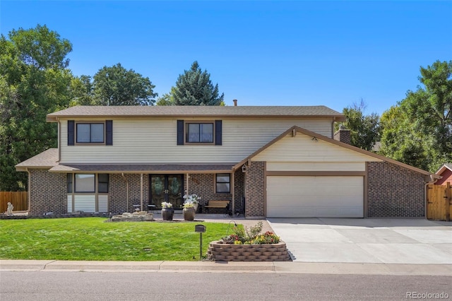 traditional-style home with an attached garage, concrete driveway, a front lawn, and fence