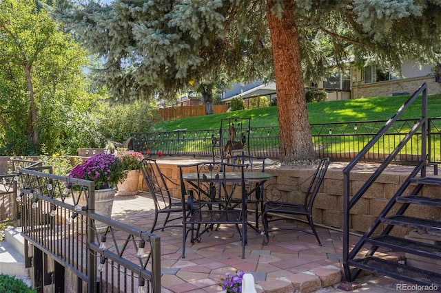 view of patio with outdoor dining space and fence