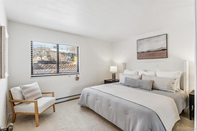 bedroom with a baseboard heating unit and light carpet