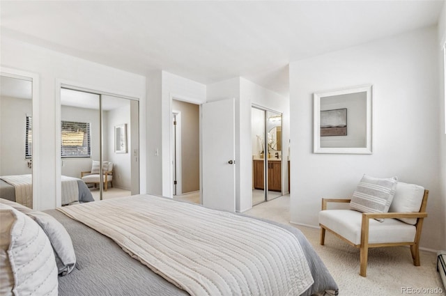 bedroom featuring light carpet, ensuite bath, multiple closets, and a baseboard radiator