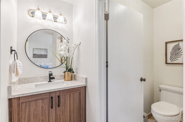 bathroom with toilet, vanity, and a baseboard radiator