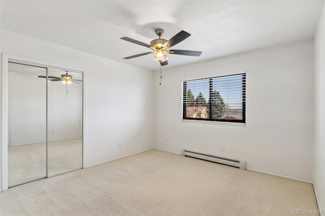 unfurnished bedroom with a closet, baseboard heating, ceiling fan, and carpet