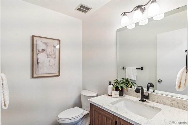 half bathroom with visible vents, toilet, and vanity