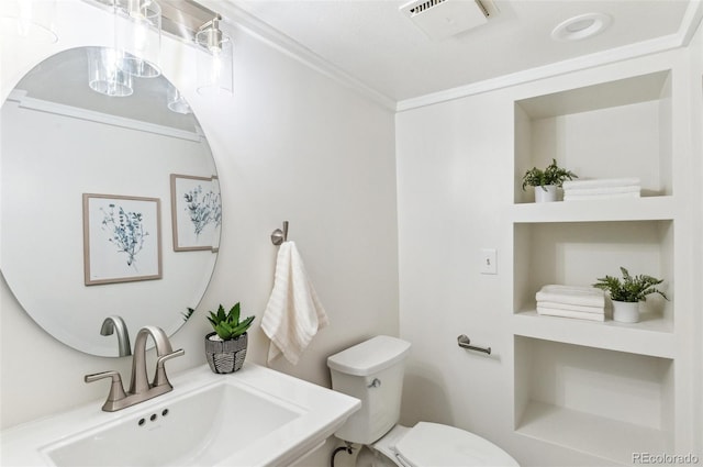 bathroom with visible vents, ornamental molding, toilet, and a sink