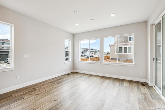 spare room with light wood-style flooring, baseboards, and recessed lighting