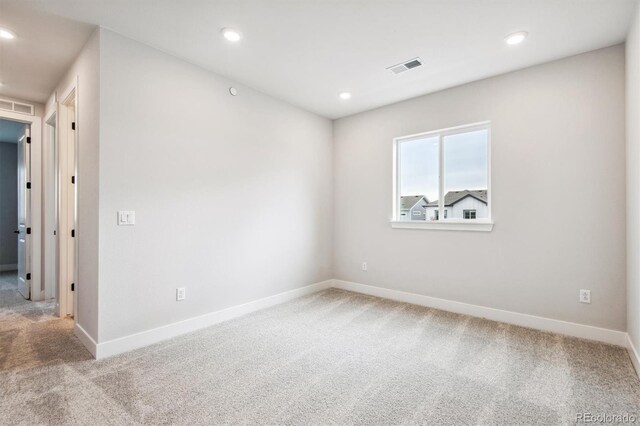 carpeted empty room featuring recessed lighting, visible vents, and baseboards