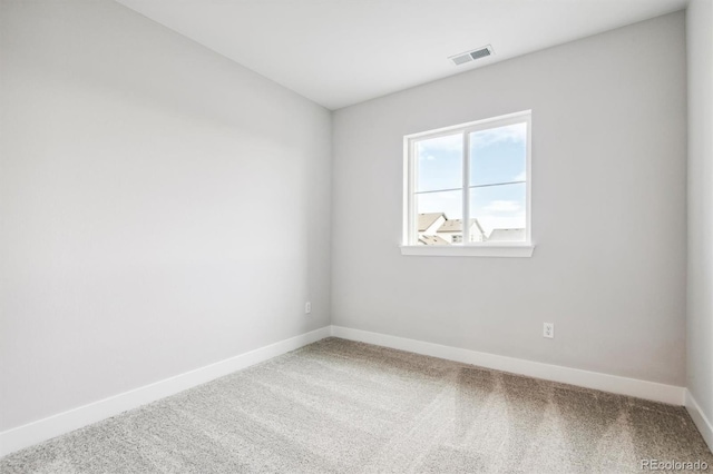 spare room with carpet, visible vents, and baseboards