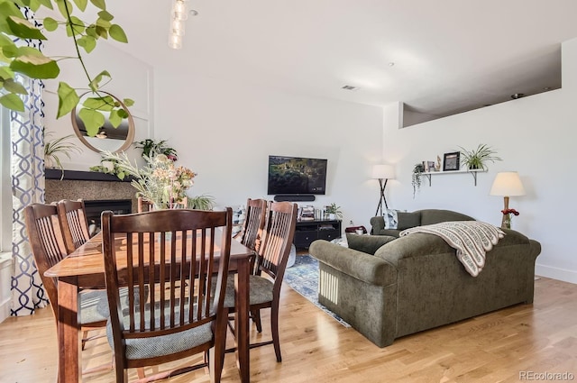 dining room with visible vents, a fireplace, and light wood-style floors