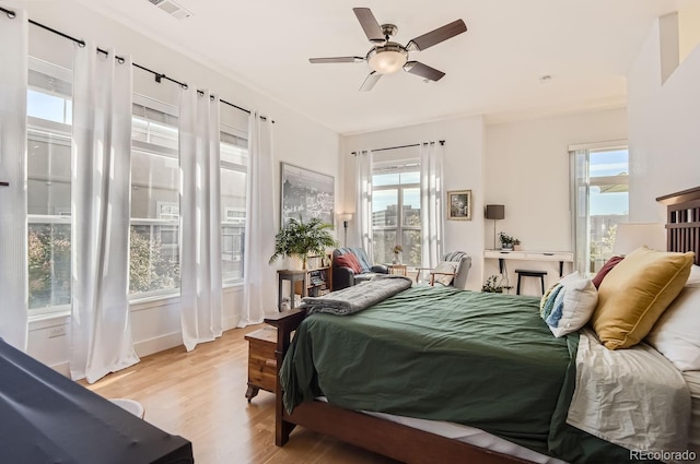 bedroom featuring a ceiling fan, visible vents, and light wood-type flooring