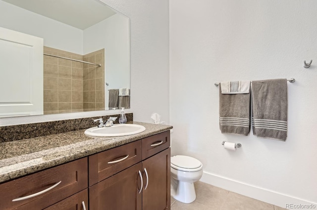 bathroom featuring tile patterned floors, toilet, tiled shower, baseboards, and vanity