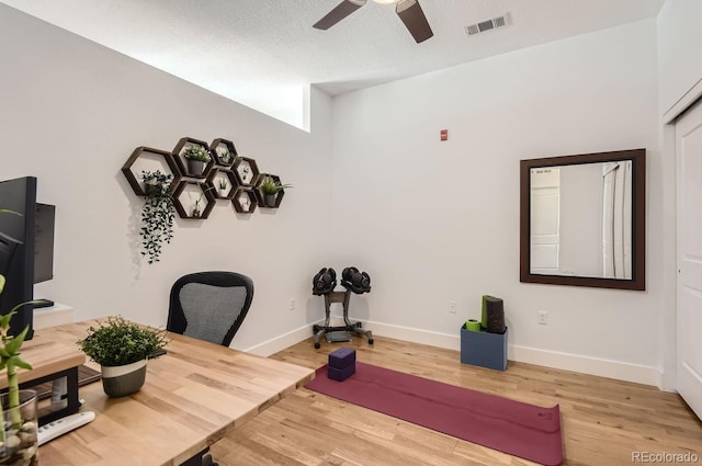 home office featuring visible vents, ceiling fan, baseboards, wood finished floors, and a textured ceiling