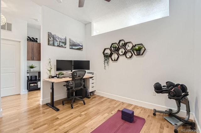 office area with light wood finished floors, visible vents, baseboards, a textured ceiling, and a ceiling fan