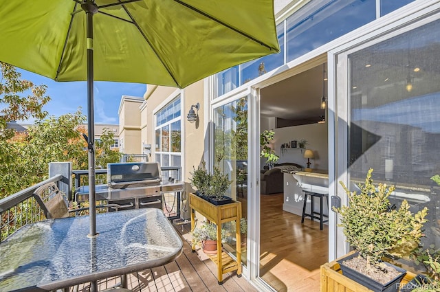 wooden terrace featuring grilling area and outdoor dining area