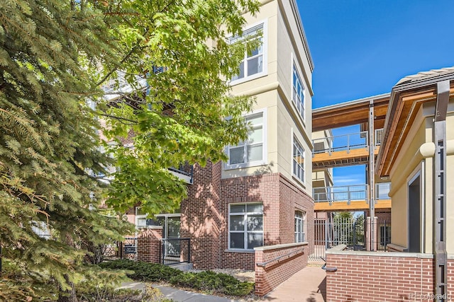 view of property exterior featuring stucco siding and brick siding