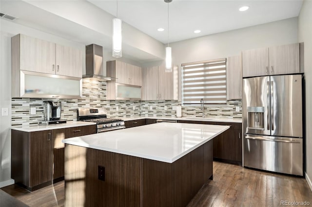 kitchen featuring wall chimney exhaust hood, visible vents, stainless steel appliances, and light countertops