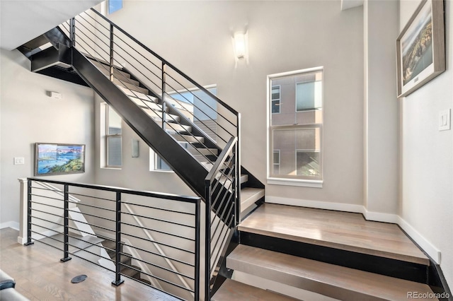 staircase featuring baseboards and wood finished floors