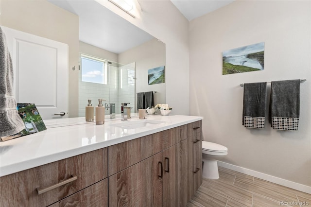 full bath featuring toilet, a shower stall, baseboards, and vanity