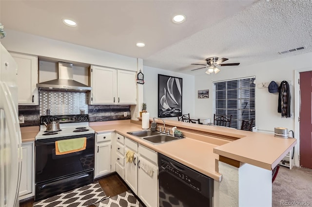 kitchen featuring a sink, a peninsula, wall chimney range hood, black appliances, and visible vents