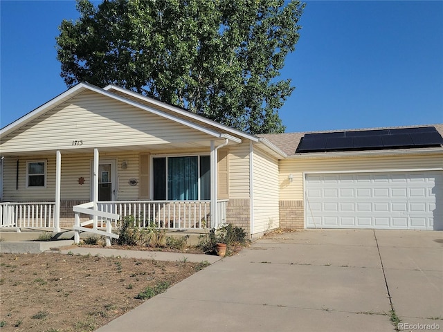 view of front of house with solar panels, a porch, and a garage