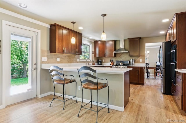 5755 S Fulton Way, Greenwood Village, CO 80111 - kitchen featuring wall chimney range hood, appliances with stainless steel finishes, a peninsula, light wood-style floors, and recessed lighting