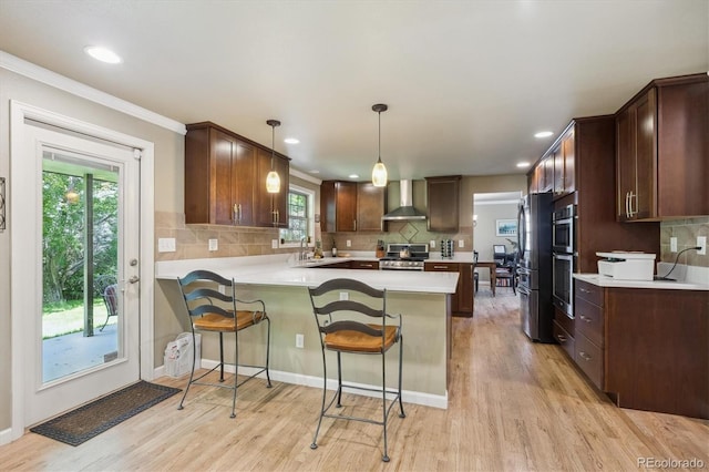 5755 S Fulton Way, Greenwood Village, CO 80111 - kitchen featuring wall chimney range hood, appliances with stainless steel finishes, a peninsula, light countertops, and light wood-style floors