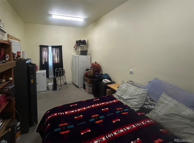 bedroom with light carpet and white refrigerator