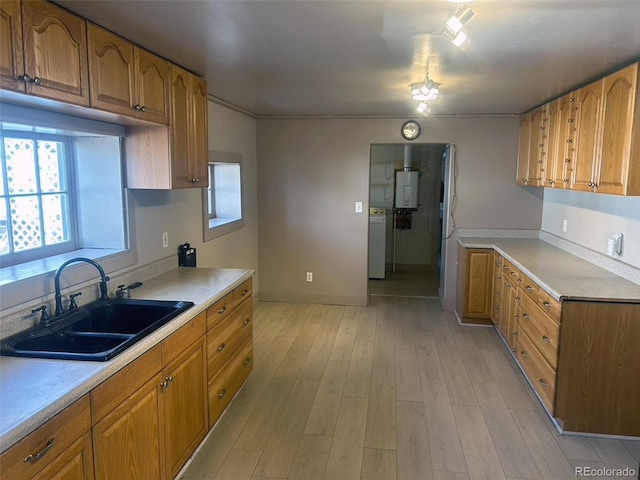 kitchen featuring light hardwood / wood-style floors, washer / dryer, and sink