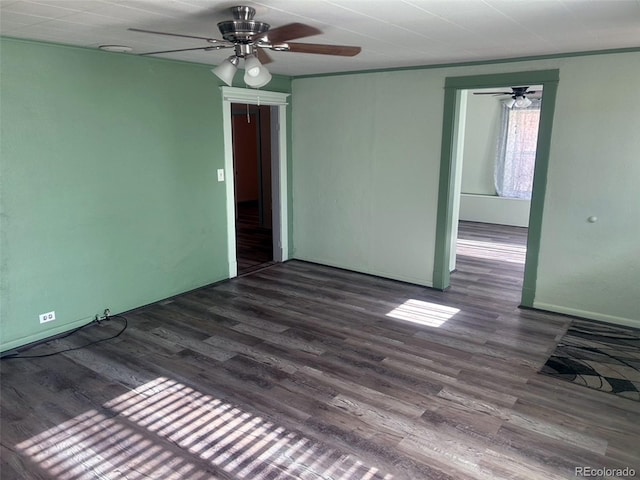 spare room featuring dark hardwood / wood-style floors, ceiling fan, and crown molding