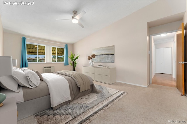 bedroom with a wall mounted air conditioner, ceiling fan, light colored carpet, and lofted ceiling