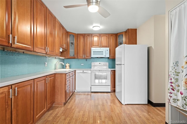 kitchen with white appliances, backsplash, sink, ceiling fan, and light wood-type flooring