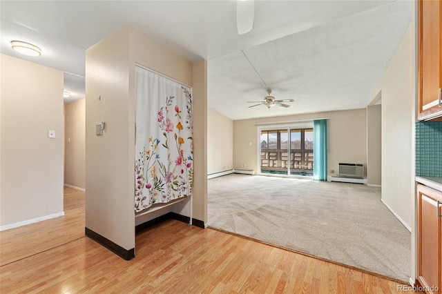 unfurnished room featuring hardwood / wood-style floors, baseboard heating, and ceiling fan