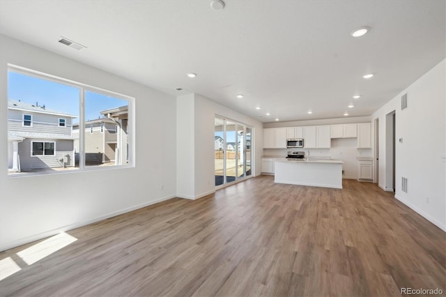 1331 Rock Cliff Ave, Erie, CO 80516 - unfurnished living room featuring recessed lighting, visible vents, and light wood-type flooring