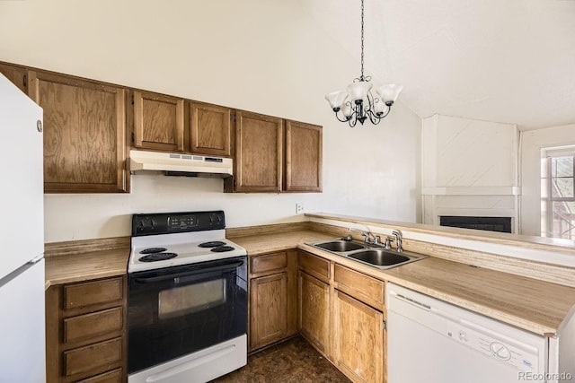 kitchen with white appliances, a peninsula, light countertops, under cabinet range hood, and a sink