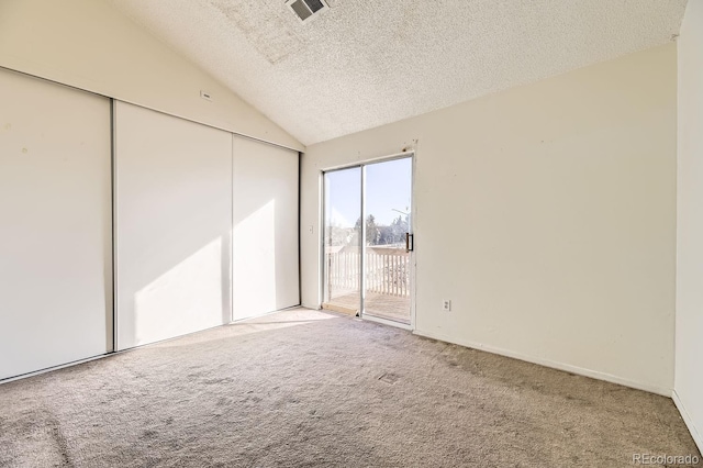 unfurnished bedroom with carpet floors, visible vents, vaulted ceiling, a textured ceiling, and access to outside