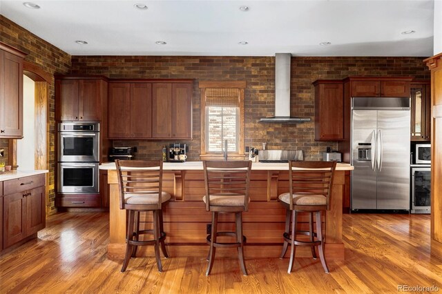 1143 S Saint Paul St, Denver, CO 80210 - kitchen featuring built in appliances, wall chimney range hood, beverage cooler, light wood-style flooring, and recessed lighting