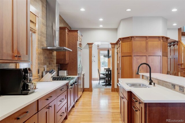 1143 S Saint Paul St, Denver, CO 80210 - kitchen featuring a sink, wall chimney exhaust hood, decorative columns, tasteful backsplash, and recessed lighting