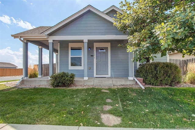 bungalow-style house featuring a front yard, a porch, and fence