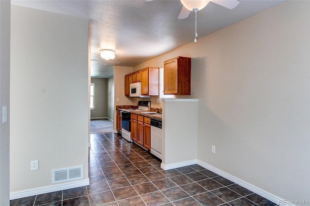 kitchen featuring dishwasher, visible vents, a sink, white microwave, and electric stove