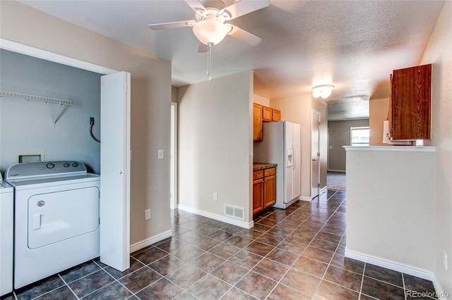 laundry area featuring washer and clothes dryer, laundry area, dark tile patterned floors, visible vents, and a ceiling fan