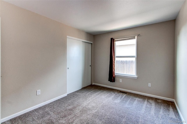 carpeted empty room with visible vents and baseboards