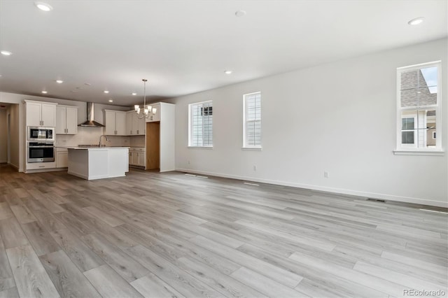 39161 Anthony St, Elizabeth, CO 80107 - unfurnished living room with plenty of natural light, a chandelier, light wood-style floors, recessed lighting, and baseboards