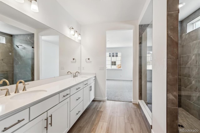 39161 Anthony St, Elizabeth, CO 80107 - full bath with wood finished floors, a tile shower, double vanity, and baseboards