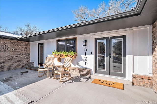 doorway to property with a patio area and brick siding