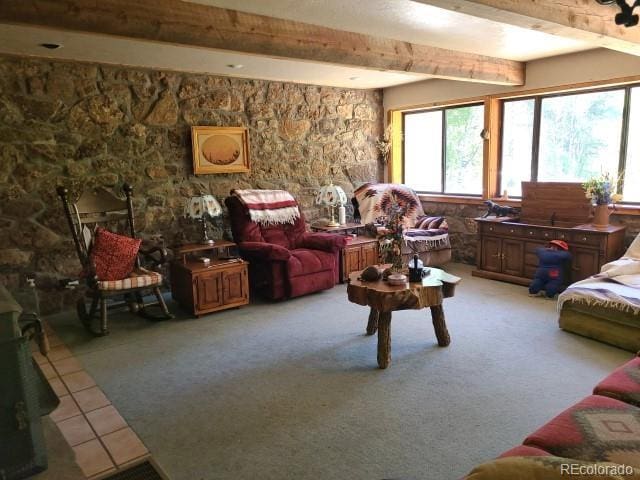 2703 Dave Wood Rd, Montrose, CO 81403 - living area featuring healthy amount of natural light, a wood stove, beamed ceiling, and light tile patterned flooring